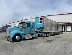 a blue semi truck parked in front of a building