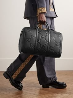 Gucci's duffle bag has been crafted in Italy from monogrammed full-grain leather and can be locked for peace of mind while travelling. It opens wide for easy access to your belongings and comes with a detachable shoulder strap. Get the matching briefcase to look polished on business trips. Duffle Bag For Men, Gucci Travel Bag, Merch Inspiration, Men Runway, Mens Designer Bag, Kash Doll, Gucci For Men, Gucci Collection, Louis Vuitton Supreme