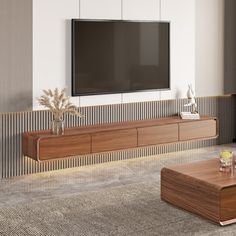 a large flat screen tv mounted on the wall above a wooden entertainment center in a living room