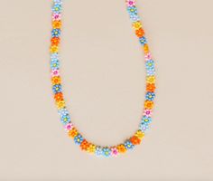 Nothing like a little daisy chain that lasts a lifetime. The Zara is hand beaded with so much love. One of our original necklaces, we always recommend Zara for a layered look, casual or dressed up, she's a perfect faux choker for everyday wear. Available in summer daisy: our combination of blue, pink, and yellow flowers with varying centers to create a bright poppy combination of flowers. - 3D Daisy chain necklace - 14k Gold fill lobster clasp - Handmade in Mexico - 17" Length 5mm width Trendy Beaded Flower Necklace Gift, Summer Flower Shaped Beaded Chain Jewelry, Summer Flower Necklace With Tiny Round Beads, Summer Floral Beaded Chain Necklace, Spring Beaded Necklaces As Gifts, Spring Beaded Necklace For Gifts, Spring Beaded Necklace As A Gift, Summer Flower Necklace With Tiny Beads, Spring Flower Necklace With Colorful Beads