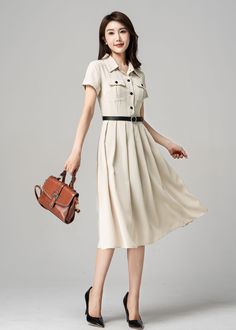 "Embrace vintage style with this stunning beige shirt dress. The dress features a classic design with pocket decorations on the front, adding a touch of elegance to the overall look. The dress is perfect for any occasion, whether it's a casual day out or a formal event. The flattering cut ensures that you look your best and feel comfortable all day long. DETAILS * Polyester fiber * Two seam pockets * Front Button up closure * Short sleeve * Notched collar * Pleated dress, shirt dress * Below kne Cream A-line Midi Dress For Work, Elegant Beige A-line Vintage Dress, Elegant Office Shirt Dress With Pockets, Spring Beige Shirt Dress With Placket, Classic Solid Color Shirt Dress For Office, Classic Shirt Dress For Office, Classic Solid Shirt Dress For Office, Beige Knee-length Semi-formal Dress, Beige Classic Semi-formal Dresses