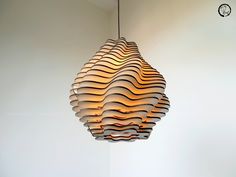 an unusual light fixture hanging from the ceiling in a room with white walls and flooring