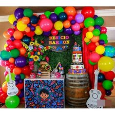 a bunch of balloons that are in front of a cake and some guitar's