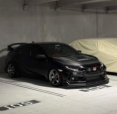 two cars parked next to each other in a parking garage with tarp coverings