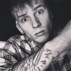 a young man with tattoos on his arm