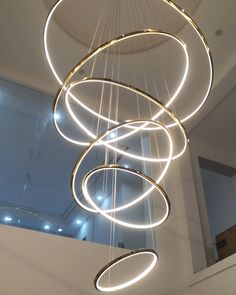 a circular chandelier hanging from the ceiling in a room with lights on it