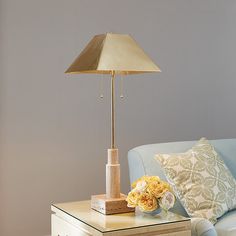 a living room with a blue couch and a lamp on top of the coffee table