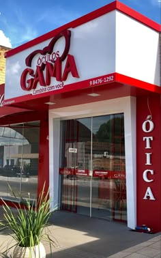 a red and white store front with the word gama on it's side