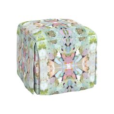 a multicolored square ottoman sitting on top of a white floor