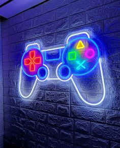 a neon gaming controller sign on a brick wall