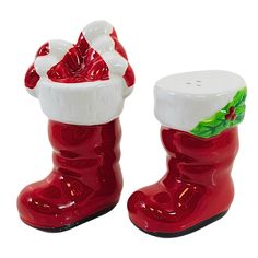 two red and white christmas boots with santa's hat on the top one has a holly berry design