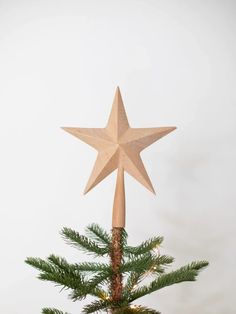 a wooden star on top of a christmas tree