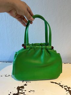 "Circa: 1950s 1960s Shamrock Green faux leather pouch handbag will be a sign of boldness. Beautiful rich green bag will hold more than you think with separate compartments. Tortoise lucite plastic bars and a simple snap closure, and that is very secure. Interior is black fabric.  DO YOU ACCEPT OFFERS? We do NOT accept offers or negotiate on pricing. We do offer layaways and have sales throughout the year. Shipping overages are always refunded. Label: Empress Fabric:  rayon interior, lucite plast Faux Leather Pouch, Wedding Bags, Rich Green, Vintage Purses, Wedding Bag, Green Vintage, Soapy Water, Bags Purses, Leather Pouch