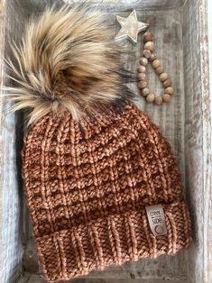 This is a handmade knit hat in a neutral toned waffle pattern made of chunky Malabrigo merino wool.  Merino wool is a warm, soft, breathable wool.  The hat is accessorized with a faux fur pom. The pom is removable, which provides versatility for wear. One size fits most.  Photos include the fit of the hat, but please note the hat modeled is not the hat for sale.   Materials:  merino wool, faux fur pom, suede tag with metal screw. Care instructions:  hand wash or spot clean with cold water.  Lay Warm Cozy Crochet Hat For Fall, Cozy Warm Crochet Hat For Fall, Yarn Hats For Cold Weather In Fall, Crochet Knit Hat For Cold Weather, Hand Knitted Crochet Hat For Cold Fall Weather, Yarn Bonnet For Cold Weather In Fall, Hand Knitted Crochet Hat For Fall And Cold Weather, Cozy Chunky Knit Hat For Fall, Fall Yarn Bonnet For Cold Weather