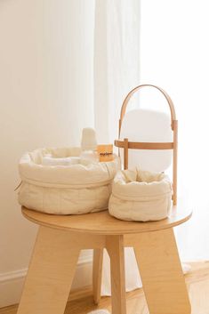 two white pillows sitting on top of a wooden table