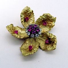 "Vintage 18 K (.750) yellow gold brooch in form of a flower, nicely detailed and decorated with Pink Sapphires and Diamonds. Diamonds are approx. 0.5 ctw, SI1-SI2 clarity, color H-I. Sapphires are approx. 0.55 ctw. This splendid brooch is 1 3/4\" in diameter and weighs 26.4 grams. EA2252" Luxury Gold Brooches With Rose Cut Diamonds, Antique Gold Diamond Brooches, Elegant Yellow Flower Brooches, Gold Diamond Hallmarked Brooches, Elegant Diamond Flower Brooch, Yellow Gold Diamond Brooches Fine Jewelry, Diamond Yellow Gold Brooches Fine Jewelry, Yellow Gold Diamond Brooch Fine Jewelry, Fine Jewelry Diamond Brooch In Gold