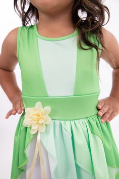 When you twirl in this enchanted green dress, it's as if you're caught in a joyful breeze, and the skirt flutters like the leaves in a magical forest. Designed for twirling - cut from a full circle of fabric which allows it to billow out as your little one spins and dances Gracefully tiered skirt, with three layers of flowing fabric that cascade elegantly Sunshine-hued flower embellishment at the waist for a finishing touch Made from breathable, stretchy, mid-grade soft knit fabrics Accessories Green Fairy Dress For Dress-up, Green Princess Dress For Dress-up, Sleeveless Green Princess Dress For Spring, Green Sleeveless Princess Dress, Fairy Style Sleeveless Dress For Garden Party, Fairy Style Sleeveless Garden Party Dress, Whimsical Green Dress For Garden Party, Sleeveless Green Princess Dress For Summer, Green A-line Dress For Garden Party