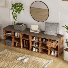 a wooden shelf with shoes on it in front of a stair case and potted plant