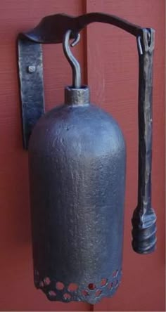 an old fashioned fire extinguisher hanging from a hook on a red door