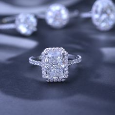 a cushion cut diamond ring surrounded by three diamonds