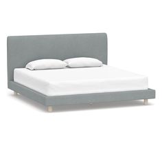 an upholstered bed frame with white pillows