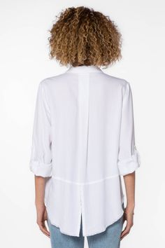 The Riley collared button down shirt features rolled tab sleeves, double chest pockets, a split back tail, and a frayed hem. This shirt is a perfect staple to any wardrobe. Material: 100% Tencel™ Eco-Friendly Machine wash cold Color: White Model is 5'9" and wearing a size S Imported Casual Blouse With Roll-up Sleeves And Shirttail Hem, Casual Tops With Roll-up Sleeves And Shirttail Hem, Classic Shirt With Roll-up Sleeves For Day Out, Layering Button-up Shirt With Pockets, Versatile Collared Shirt With Button Cuffs, Chic Blouse With Rolled Sleeves For Daywear, White Blouse With Shirttail Hem And Placket, Classic Shirt With Rolled Sleeves For Day Out, Classic Shirttail Hem Blouse For Spring