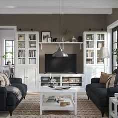 a living room filled with furniture and a flat screen tv on top of a white table