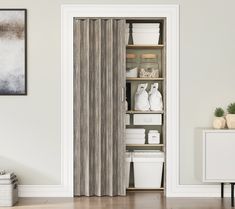 an open closet door with white containers on the shelves and other items in front of it