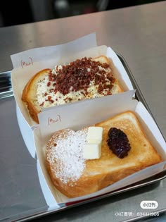 two pieces of bread with cheese, jam and jelly on them in a white box