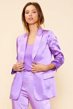 Elevate your look with our luxurious long sleeve satin blazer. Featuring a unique light purple hue, this blazer is made of a satin finish with a lightly lined interior. With classic detailing like flap front pockets and one button closure, you're sure to impress with this timeless, yet modern, style. Sleek Silk Blazer For Spring, Semi-formal Fall Satin Blazer, Semi-formal Satin Blazer For Fall, Fall Semi-formal Satin Blazer, Purple Notch Lapel Blazer, Sleek Spring Blazer With Pockets, Notch Lapel Satin Outerwear For Party, Sleek Blazer With Pockets For Spring, Satin Notch Lapel Outerwear For Party