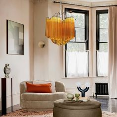 a living room filled with furniture and a chandelier hanging over the top of it