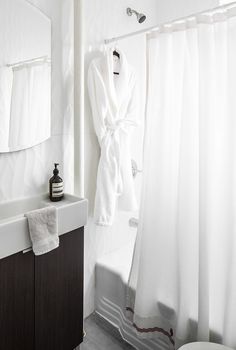 a white robe hanging on the shower curtain