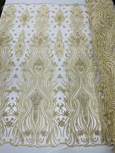 the fabric is white with gold thread and sequins on it's edges