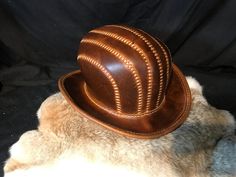 "Leather Steampunk Bowler Hat Made with Crazy Cow (Coach) Leather. This leather has some Amazing markings making each item a real one off. There is no way there will be another like this one, even if you use the same colour leather. Head Size is 60\" I can Make these to order if you need another size or colour then please do get in touch. Materials Used: 1.8mm-2mm Leather Wax Thread Curved Metal Wire Hat length - 33cm Hat Width - 28cm Hat height - 16cm All Hand Stitched. Please message us with any questions! Happy Shopping! Less" Leather Face Mask, Bowler Hat, Leather Wear, Leather Hats, Real One, Coach Leather, Metal Wire, Hat Making, Hat Shop