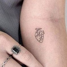 two people with tattoos on their arms, one has a heart tattoo and the other has a diamond ring