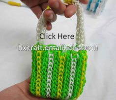 a hand holding a small green and white bag with handles made out of plastic yarn