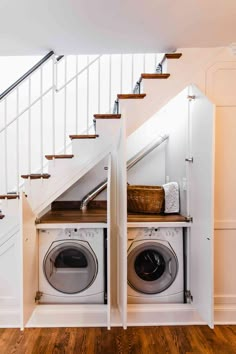 a washer and dryer are under the stairs in this laundry room with wood flooring