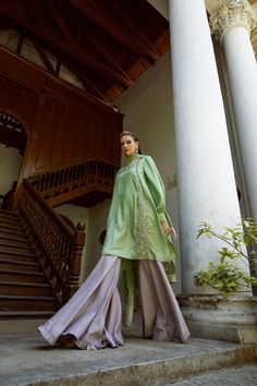 DETAILS Boat neck shirt with a buttoned, side pleat, delicately hand embroidered. Exaggerated balloon sleeves, pleated cuffs, and embellished ties. Paired with a contrasting gharara, pleated edge. Organza dupatta with embroidered motifs and embroidered panels. COLOR Green / Grey SIZE Custom Order - A measurement guide will be sent upon order. Model is 5'7 MATERIAL Shirt - Silk Katan Self JamawarGharara - Raw SilkDupatta - Khaddi Spun Silk Net / Silk Organza PRODUCT CODE 300000-08-28 PRODUCT OF P Elegant Green Kurta With Embroidered Sleeves, Spring Kurta With Embroidered Cuffs And Long Sleeves, Spring Long Sleeve Kurta With Embroidered Cuffs, Silk Long Sleeve Blouse For Eid, Eid Long Sleeve Silk Blouse, Elegant Kurta With Embroidered Cuffs For Eid, Eid Long Sleeve Blouse With Embroidered Sleeves, Long Sleeve Silk Blouse For Eid, Wedding Sets With Embroidered Cuffs Long Sleeve