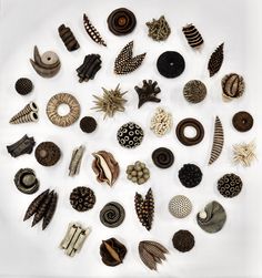 a group of different types of buttons on a white surface with black and brown designs