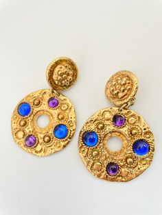 "Gorgeous gold round drop earrings with glass cabochons in, purple and blue. Awesome statement earrings! Nice vintage condition. clip style. approx 3\" long. on the heavier side. Please Note: All of these items are vintage. They have been pre-loved and are not in pristine condition. I try to take photos of any areas of concern. Please ask for more photos if you have any concerns about the condition of a piece. Returns will only be accepted if there is damage in shipping." Unique Gold Cabochon Earrings, Victorian Cabochon Drop Earrings, Luxury Gold Cabochon Earrings, Vintage Cabochon Metal Earrings, Luxury Vintage Cabochon Earrings, Statement Earrings, Blue And Purple, Jewelry Inspiration, Beautiful Jewelry