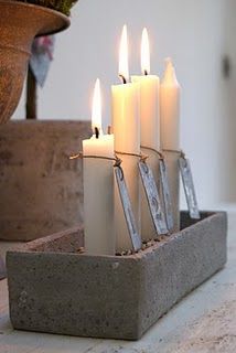 several lit candles are placed in a concrete holder