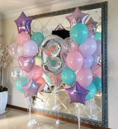 balloons and stars are arranged in the shape of a number on a mirror frame at a birthday party