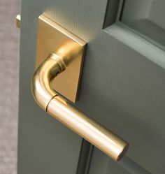 a close up of a door handle on a grey door