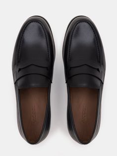 Color: black Cow leather with natural finish Penny front Leather insoles Rubber and leather soles Hand-stitched detailing Business Moccasins With Stitched Sole And Round Toe, Black Almond Toe Slip-ons With Leather Sole, Black Slip-ons With Leather Lining And Round Toe, Black Leather Moccasins For Business, Black Leather Loafers For Business Casual, Black Calf Leather Loafers With Stitched Sole, Black Leather Loafers With Textured Sole, Black Leather Plain Toe Loafers, Black Moc Toe Slip-ons With Leather Sole