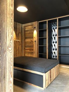 a bed sitting in the middle of a room next to a book shelf filled with books