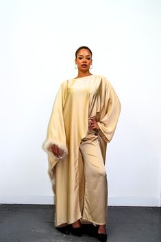 Embrace timeless elegance with our exquisite Satin Abaya Co-Ord Set. This stunning two-piece ensemble features a luxurious, soft-flowing satin fabric that drapes beautifully and flatters your figure. The elegant abaya boasts a modest silhouette, perfect for everyday wear or special occasions. The highlight of this set is the exquisite fur trim. This touch of luxury adds a touch of sophistication and warmth to the design, making it perfect for cooler evenings or formal events. Key Features Luxurious Satin Fabric: Experience the soft, smooth feel of premium satin that flatters your form. Elegant Abaya Silhouette: This modest design offers full coverage while maintaining a stylish and graceful drape. Delicate Fur Trim: Elevate your look with a touch of luxury and warmth. Two-Piece Co-Ord Set: Elegant Cape Kaftan For Eid, Elegant Evening Thobe In Maxi Length, Elegant Eid Abaya With Cape, Elegant Floor-length Party Thobe, Elegant Long Sleeve Solid Color Kaftan, Evening Solid Color Maxi Length Abaya, Evening Solid Maxi Length Abaya, Evening Maxi Length Solid Abaya, Elegant Gold Thobe For Party