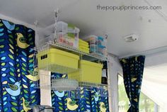 a kitchen with blue curtains and yellow bins