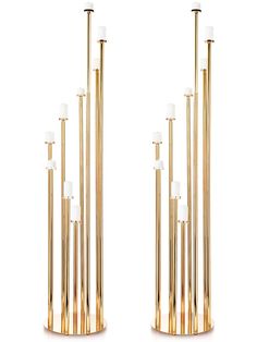 two tall gold candles are next to each other