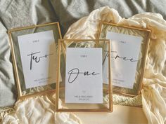 two frames with writing on them sitting on a bed