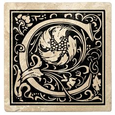 a black and white tile with an ornamental letter q in the center, surrounded by swirls and flowers